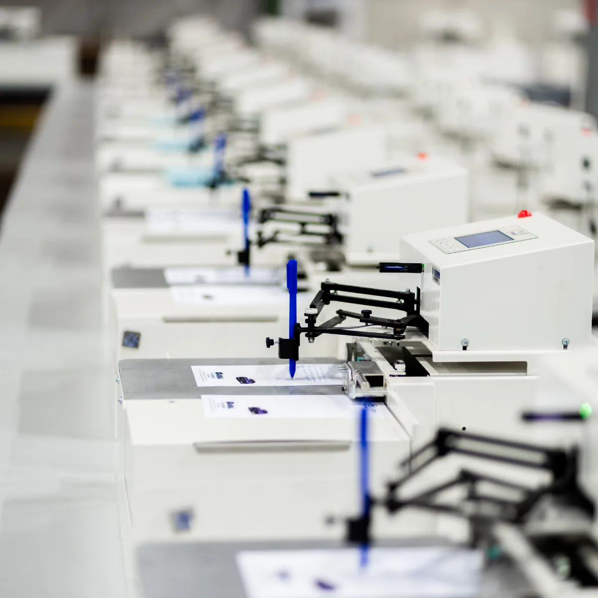 Production line of Uniprod handwriting machines writing direct mail at scale